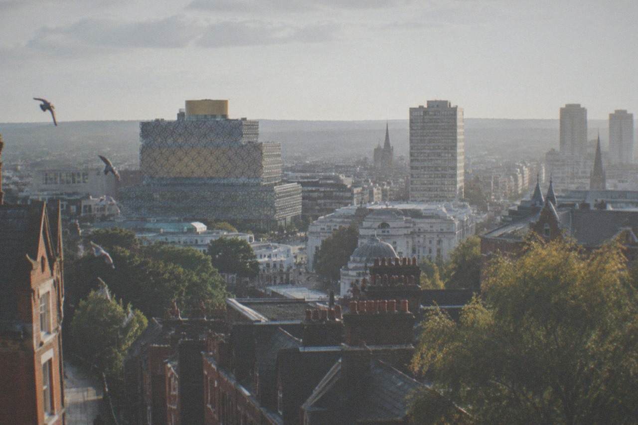 View over Birmingham city centre rooftops towards the Library of Birmingham on a bright afternoon